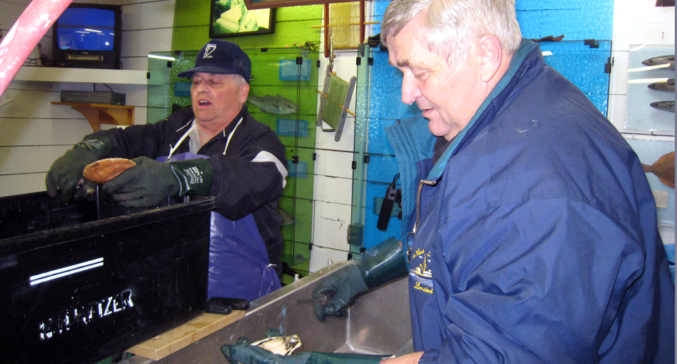 Norman Keizer (foreground) and Wallace Skinner, scallop shucking champions at the Fisheries Museum of the Atlantic, Lunenburg