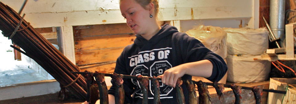 Volunteer Megan Ingalls holds rack of smoked herring, Sardine Museum and Herring Hall of Fame